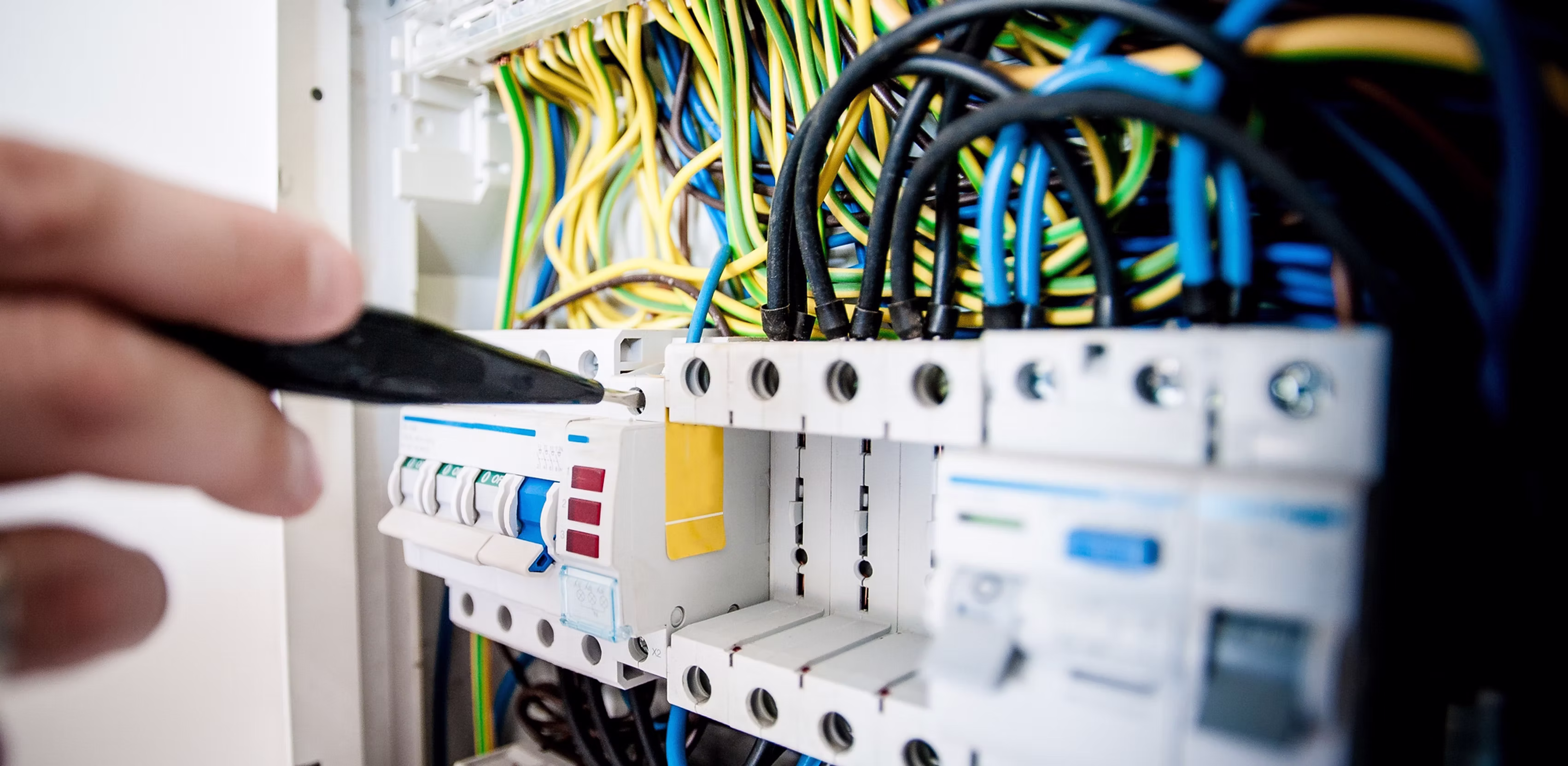 Elektroinstallateur von M-Elektrotechnik bei der Arbeit am Sicherungskasten